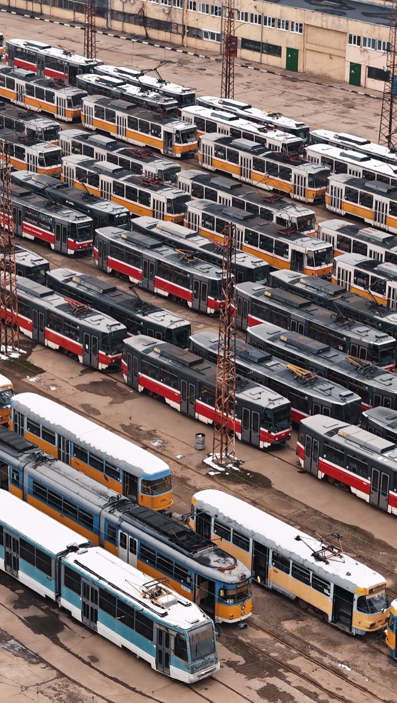 Hundreds of yellow, red and white trams packed into a depot yard.